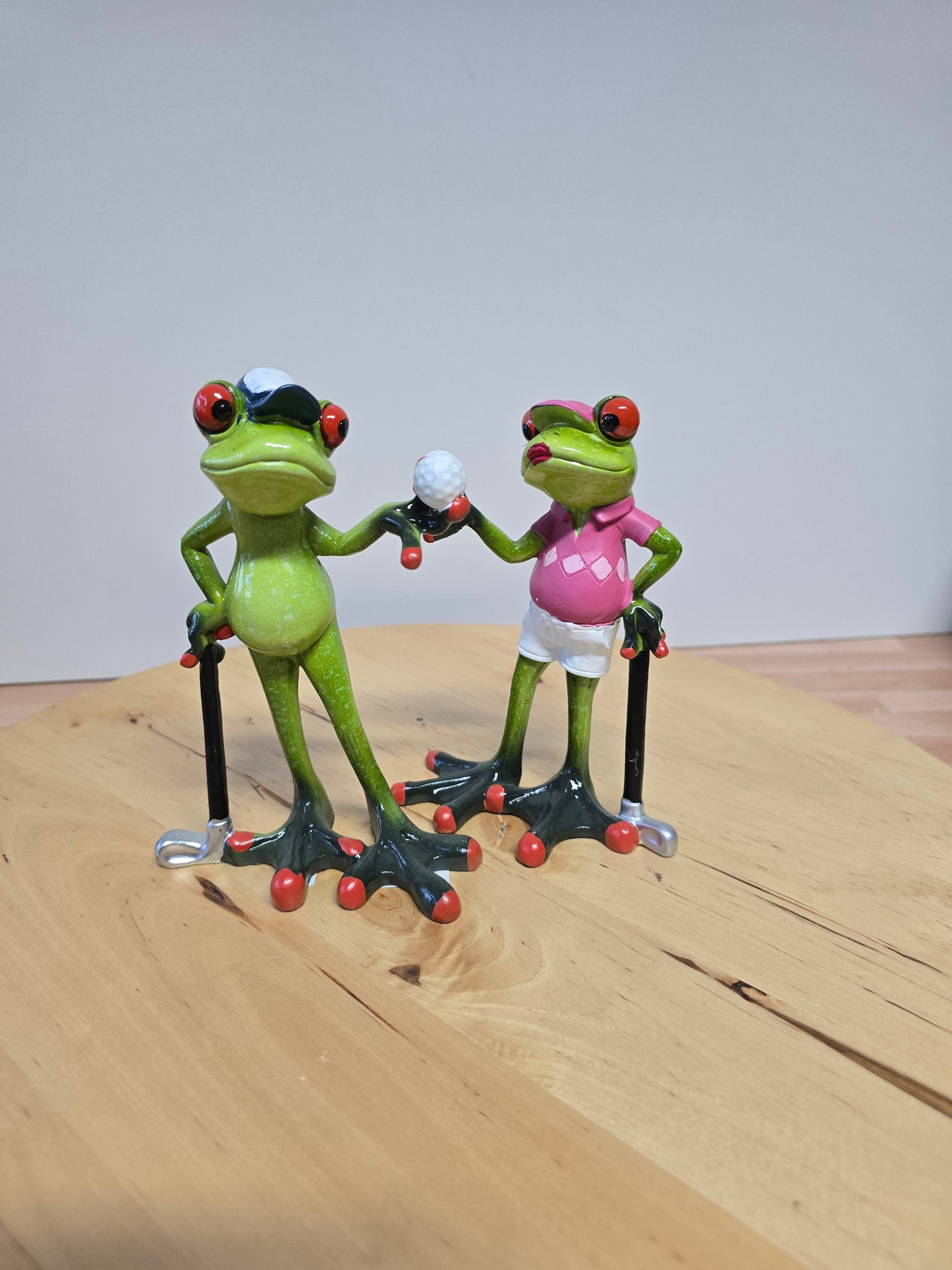 Frösche Golf spielend